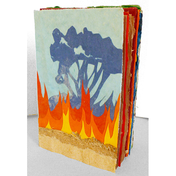 An image of a book made of cut paper, closed. A collage of colored paper shows a tree burning.