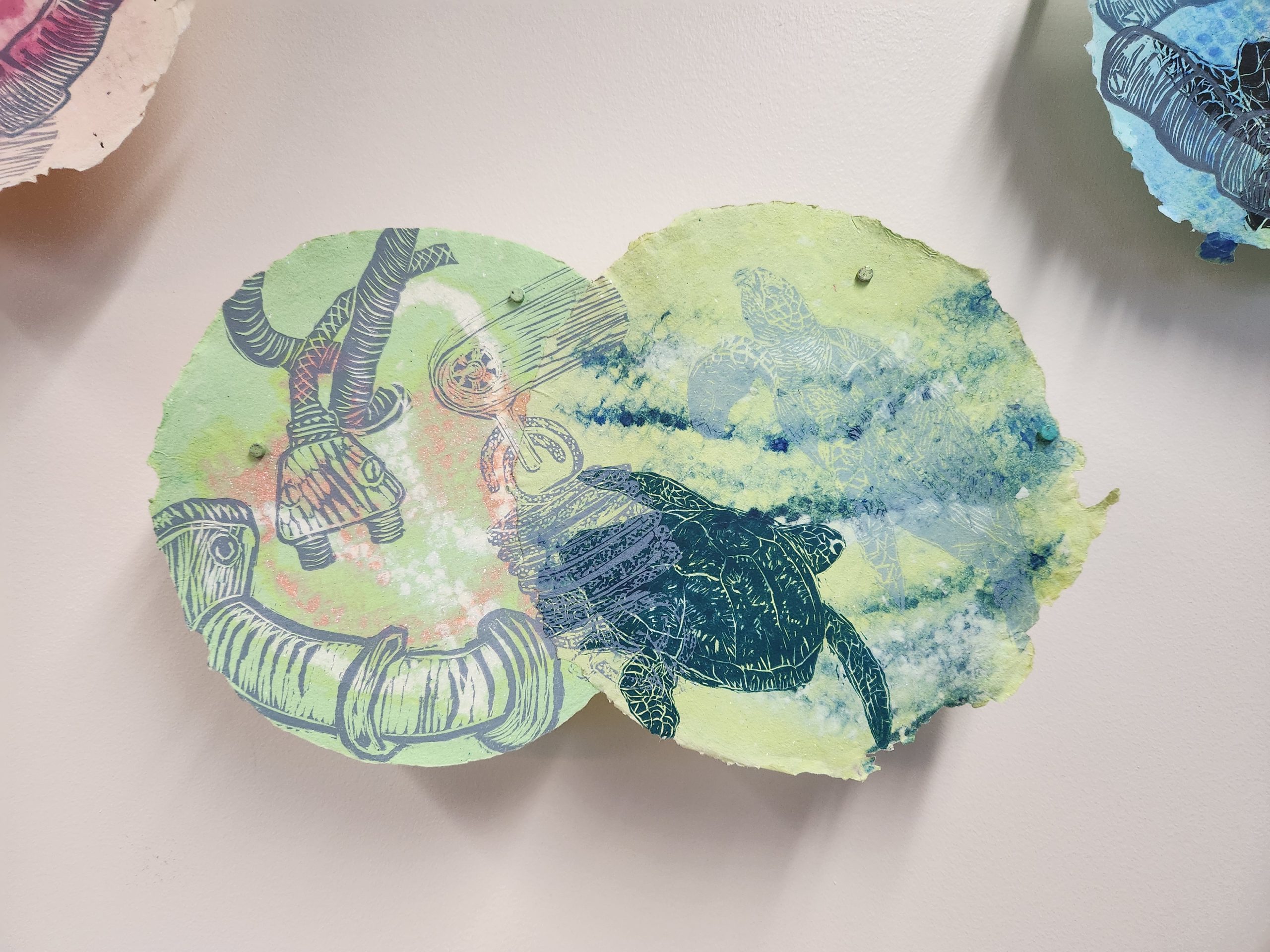 Marilyn Propp, "Ghost Divers," 2014. Relief print on handmade cotton paper with pulp painting, 9 ¾ x 16 ⅛ in. Part of "Pulped Under Pressure," 2022. Installation view, Glickman Family Library.