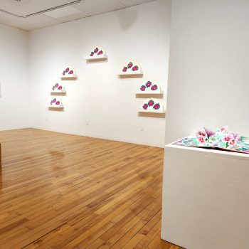 Works by Artist Annie Lee-Zimerle. Front right: "Mugunghwa (무궁화:
Rose of Sharon)," 2022. 
Pop-up book: watercolor and crayon on paper, book board and cloth
18 1⁄2 x 28 x 7 3⁄4 in. (open) | 18 1⁄2 x 14 in. (closed). "Hidden Stories," 2023. University of Southern Maine Art Gallery. Photo by Kat Zagaria Buckley. 