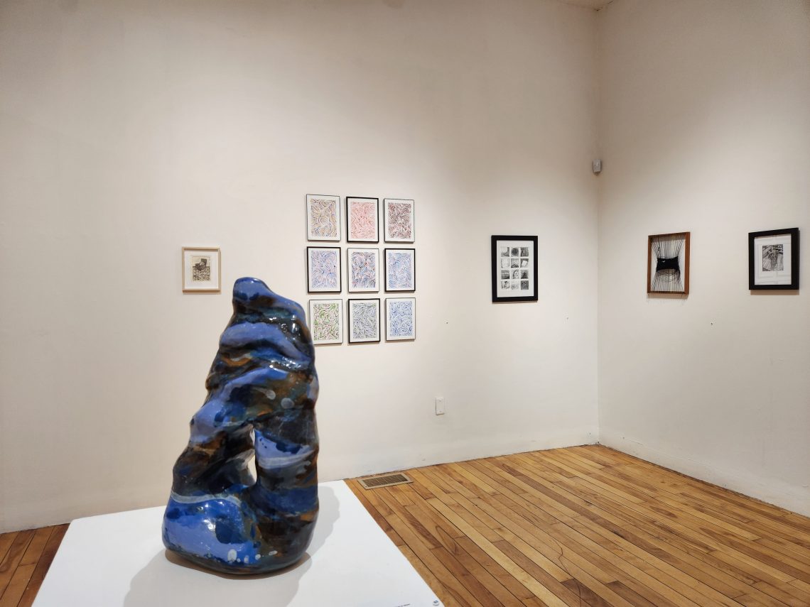 Installation view, "Parallel Convergence: The 2023 University of Southern Maine Juried Student Exhibition," University of Southern Maine Art Gallery. Foreground: Krystal Yavicoli, "Submerge," 2022. Stoneware and glaze. 21 in. high x 11 in. wide x 8 in. deep. 3rd Place Winner, Best-in-Show.