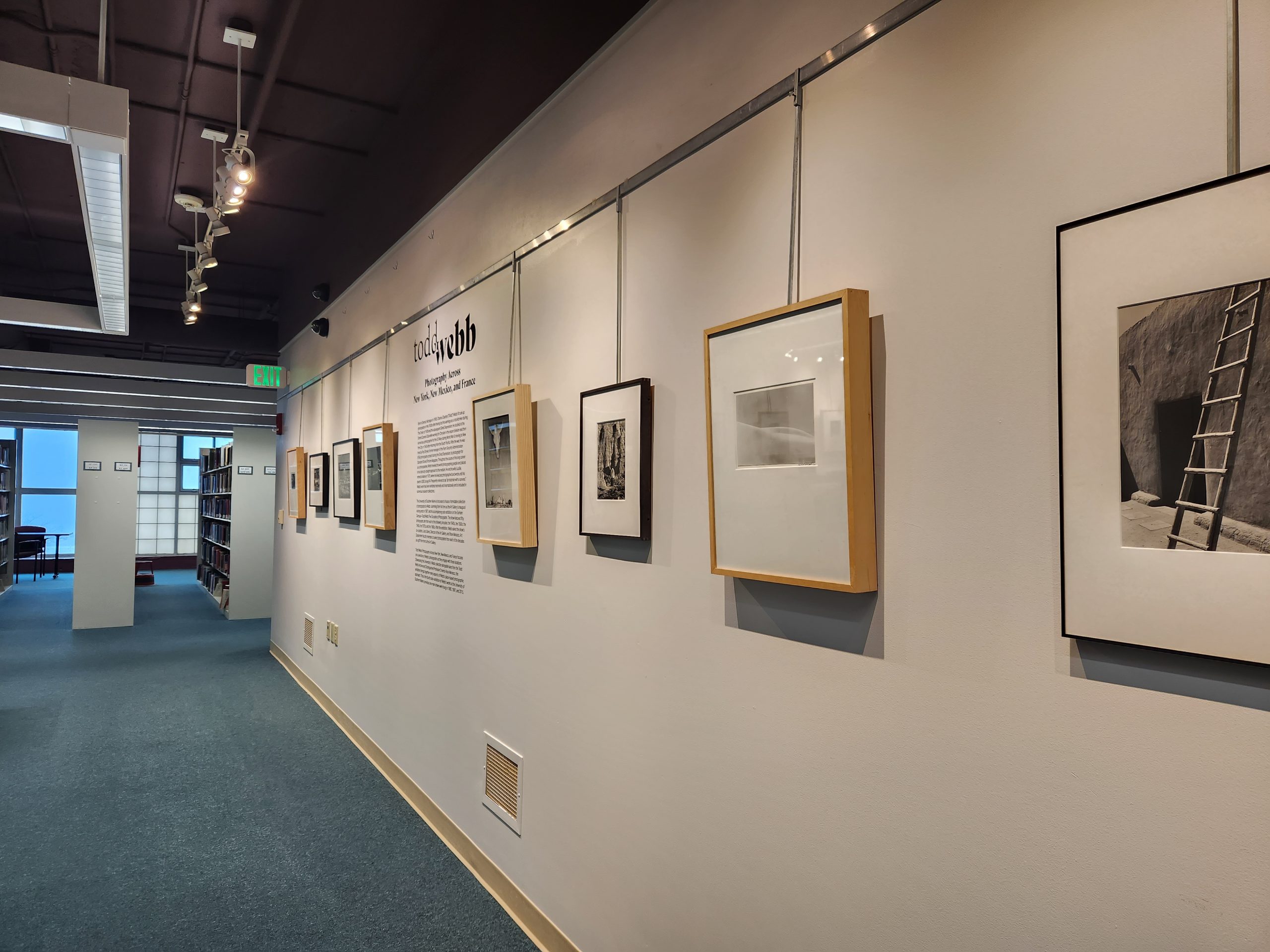 Foreground Right: "O’Keeffe’s House, Abiquiu, New Mexico," 1957. Silver Gelatin Print. 22 x 16 cm. Todd Webb Archive. Installation view, "Todd Webb: Photography Across New York, New Mexico, and France." University of Southern Maine Glickman Library, 2023.