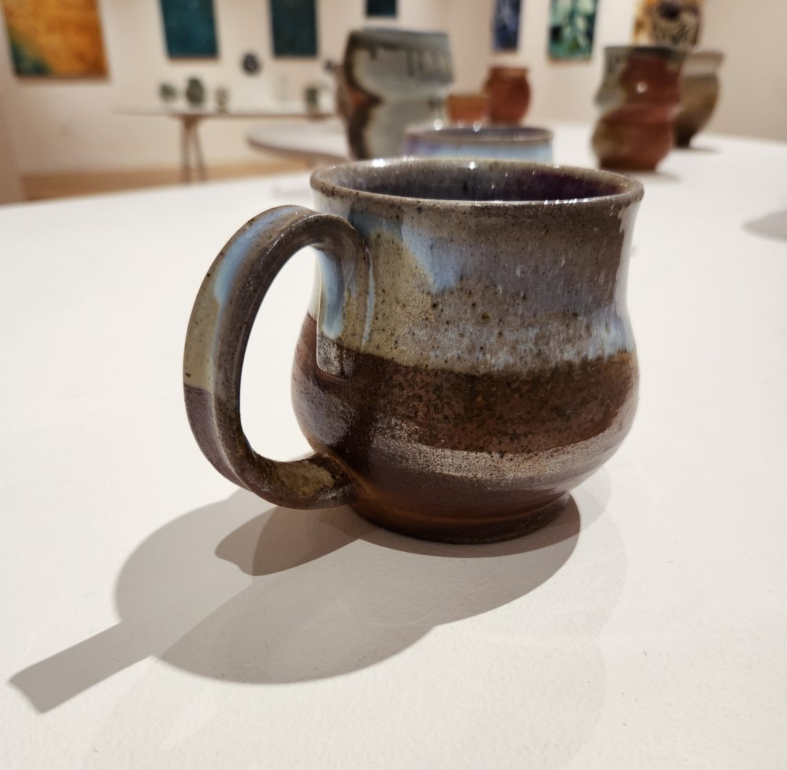 Annika Soderberg "Heaven's Gate Mug II" 2022. Stoneware, 5in. long x 4in. wide x 3in deep. Part of the "2023 Bachelor of Fine Arts and Bachelor of Arts Exhibition," University of Southern Maine Art Gallery.