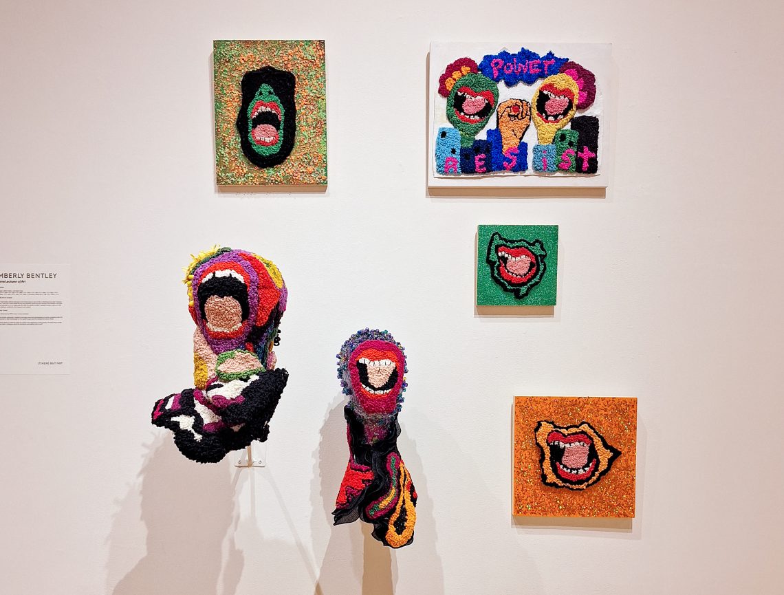 Kimberly Bentley, "Protest Series," 2023. Wood, glitter, glue, plastic beads, mannequin head. Multiple pieces. Part of "(T)HERE BUT NOT: The 2024 University of Southern Maine Art Department Exhibition," Installation view, 2024. University of Southern Maine Art Gallery.