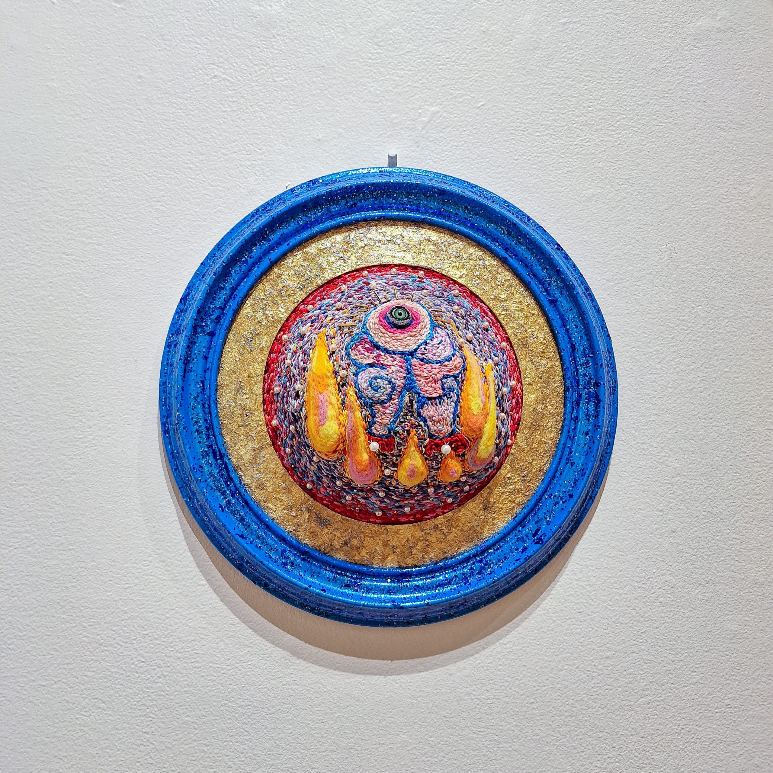 Kaitlyn Hunter, "Burn Bright Darling," 2023-24. Embroidery and felting, 13 in x 13 in x 5 in. Part of "(T)HERE BUT NOT: The 2024 University of Southern Maine Art Department Exhibition," Installation view, 2024. University of Southern Maine Art Gallery.