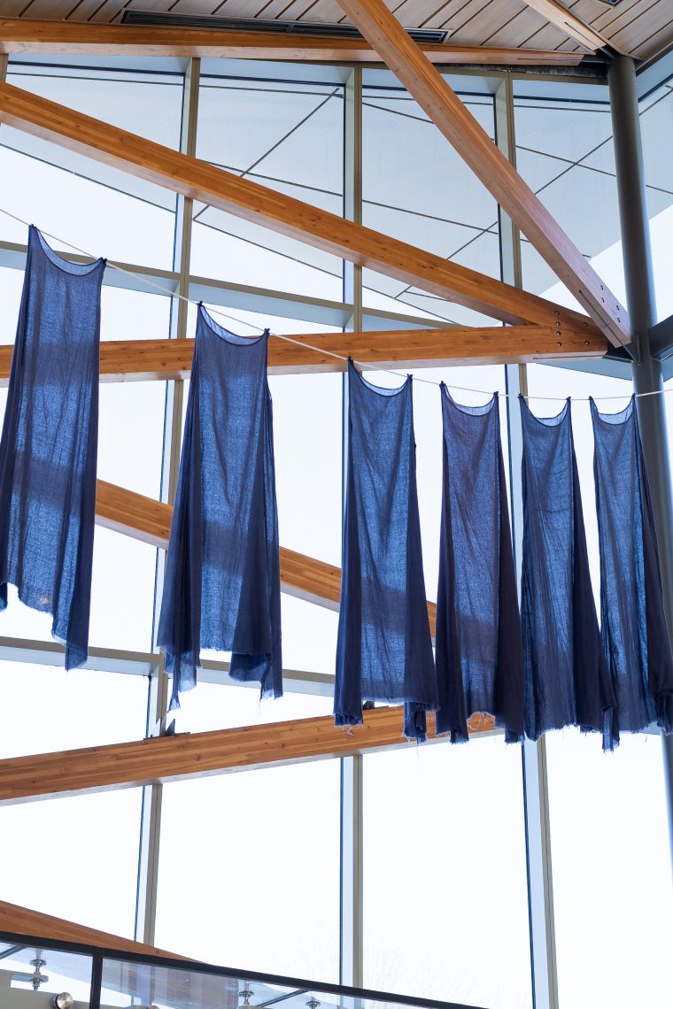 Susan Bickford, "Invoking the Muses," 2026. Nine handmade blue cotton voile dresses, cotton line. Dimensions variable. Part of "Of Sibyls and Source: Ranges and Ruptures," 2026. Crewe Center for the Arts at the University of Southern Maine. Photo: Marion Earley.