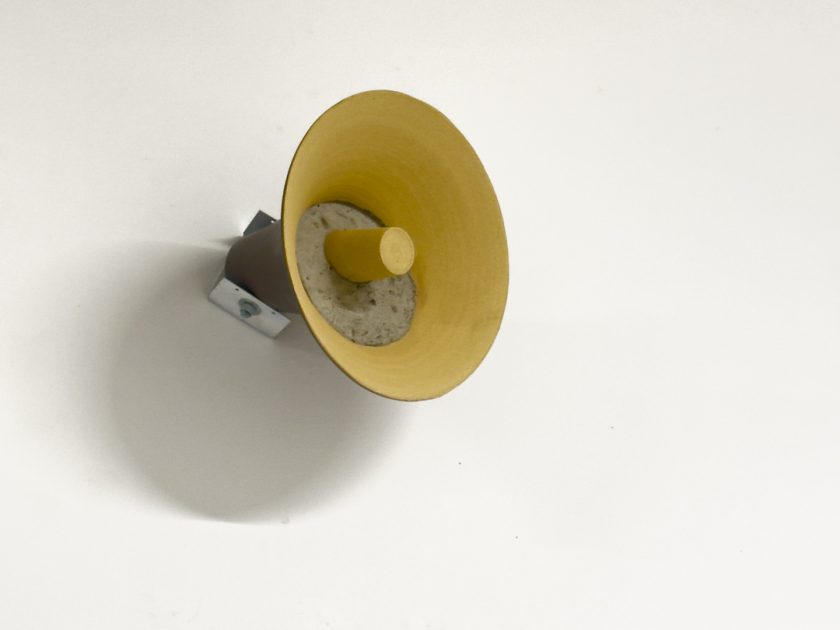 An image of a yellow loudspeaker filled with concrete