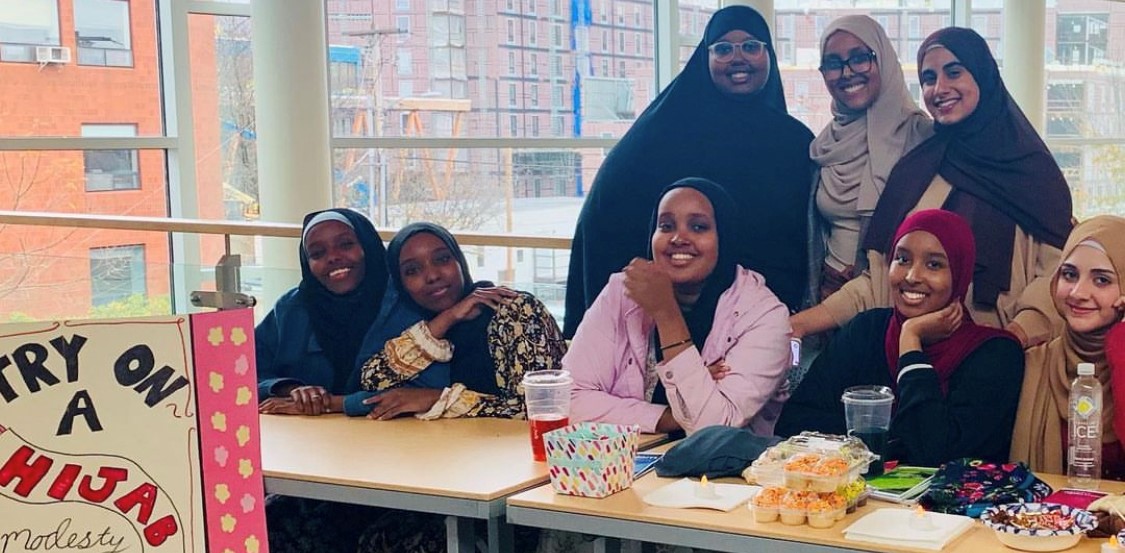 Photo of smiling MSA students hosting a "try on a hijab" event.