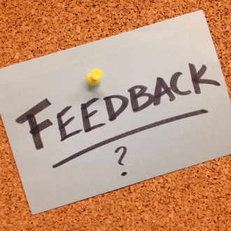 Feedback? written on a piece of paper and tacked to a cork board