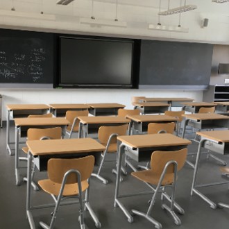 Classroom with individual desks in front of a large chalkboard