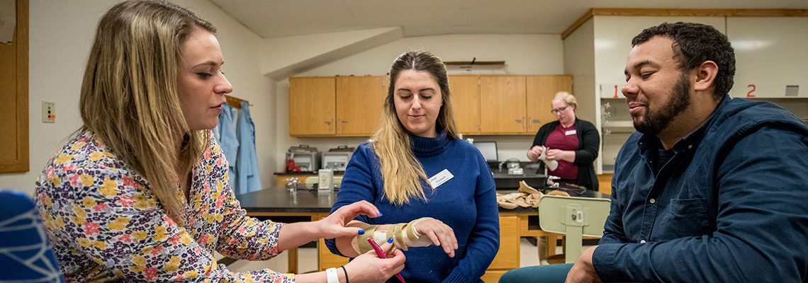 An Occupational Therapy faculty member demonstrates splinting with two graduate students at the Lewiston-Auburn Campus.