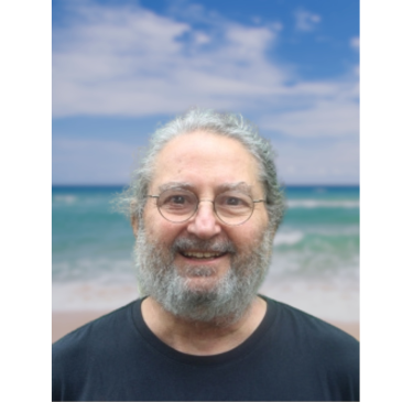 Professor Shedletsky wearing a blue tshirt standing on a beach