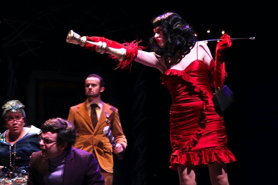 Miss Scarlet wields the candlestick holder in Clue: On Stage.