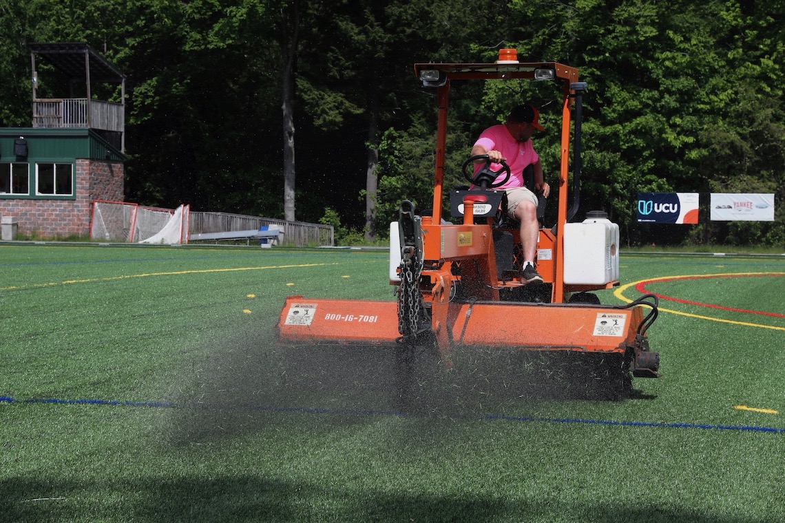 Infill is applied to new artificial turf at Hannaford Field.