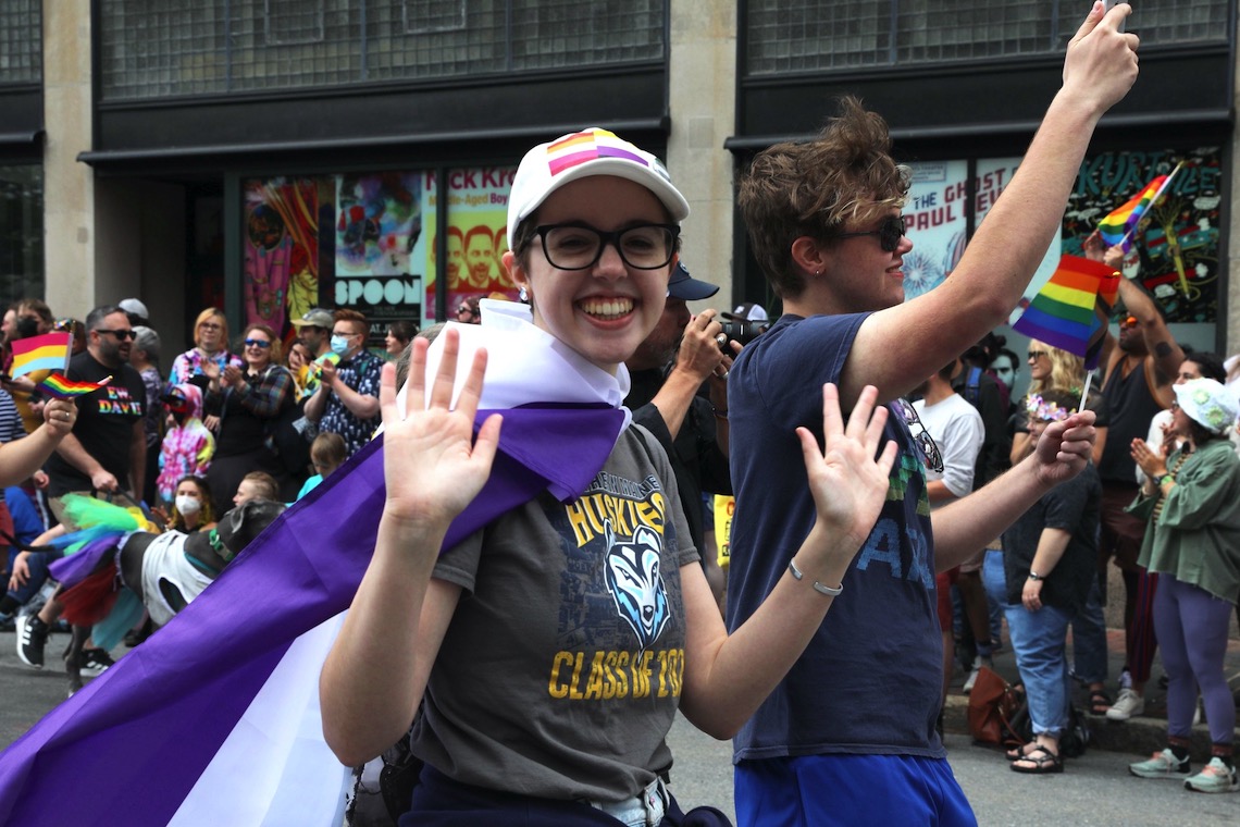 Marcher waves to the camera at 2022 Pride Portland! parade.
