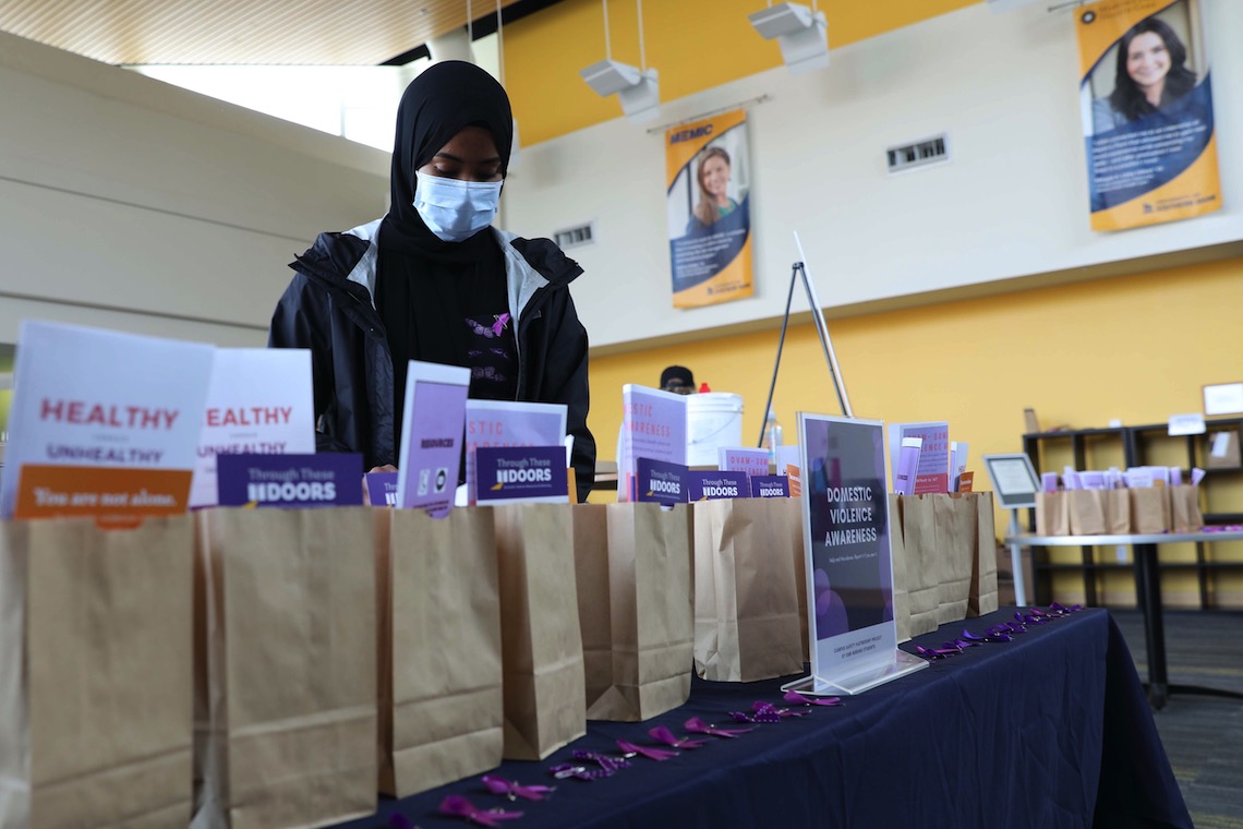 Habon Khalid fills bags with information about resources to deal with domestic violence.
