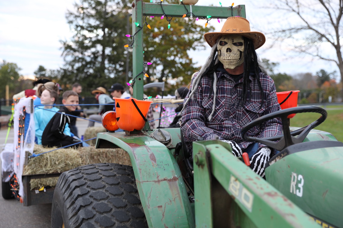 The driver of the haunted hayride pauses to pick up the next group of riders at the Husky Community Halloween Party.