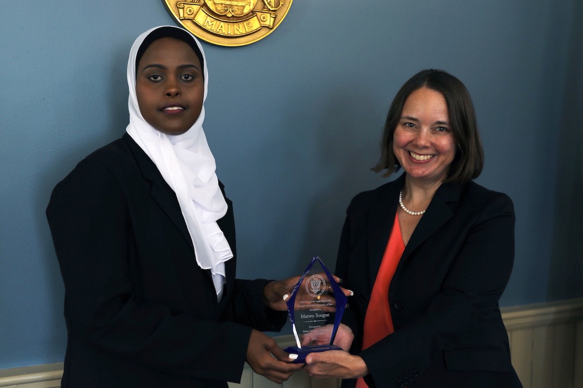 Maine Secretary of State Shenna Bellows presents Marwo Sougue with the John Lewis Youth Leadership Award.
