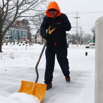 Custodial workers keep walkways clear after a Feb. 2022 snow storm.