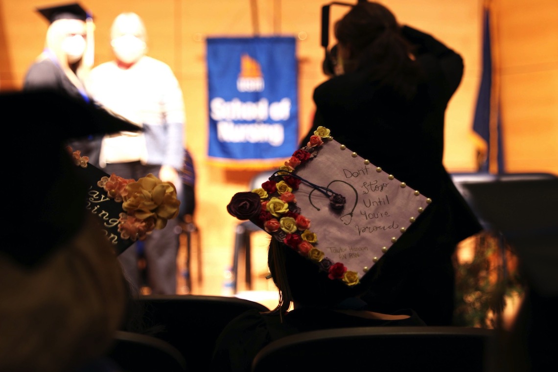 The cap worn by a Nursing program graduate reads "Don't stop until you're proud."
