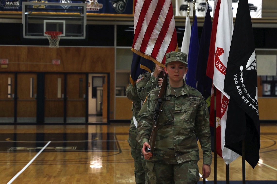 A color guard from the ROTC program presents the U.S. flag at a ceremony for the POW/MIA Chair of Honor.