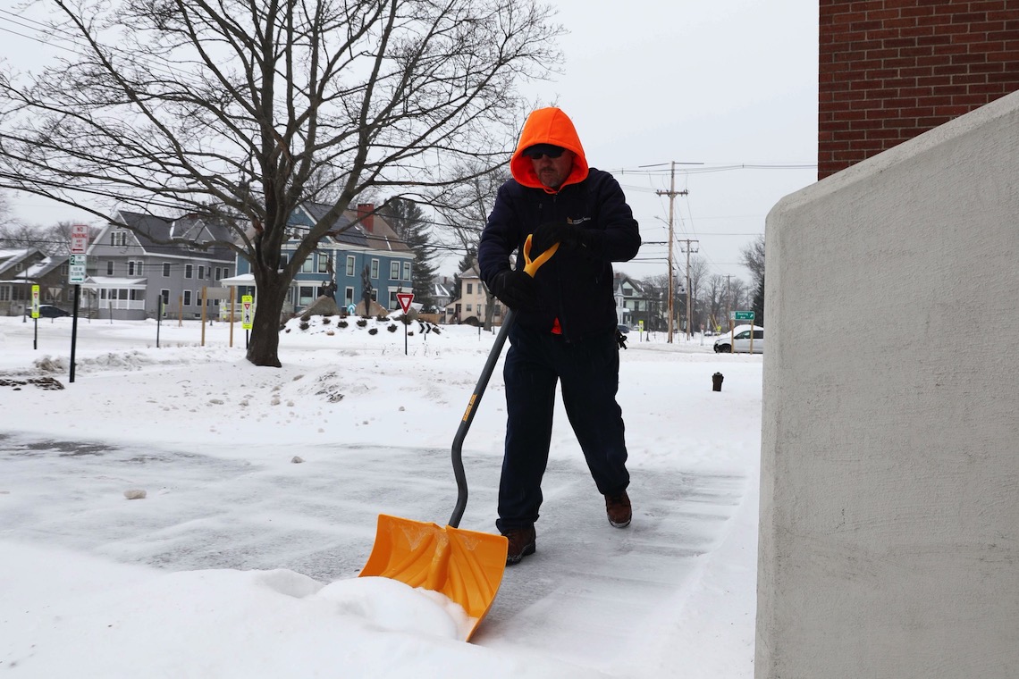 Custodial crews work by hand to make sure the entrances to campus buildings are passable after a Feb. 2022 snow storm.