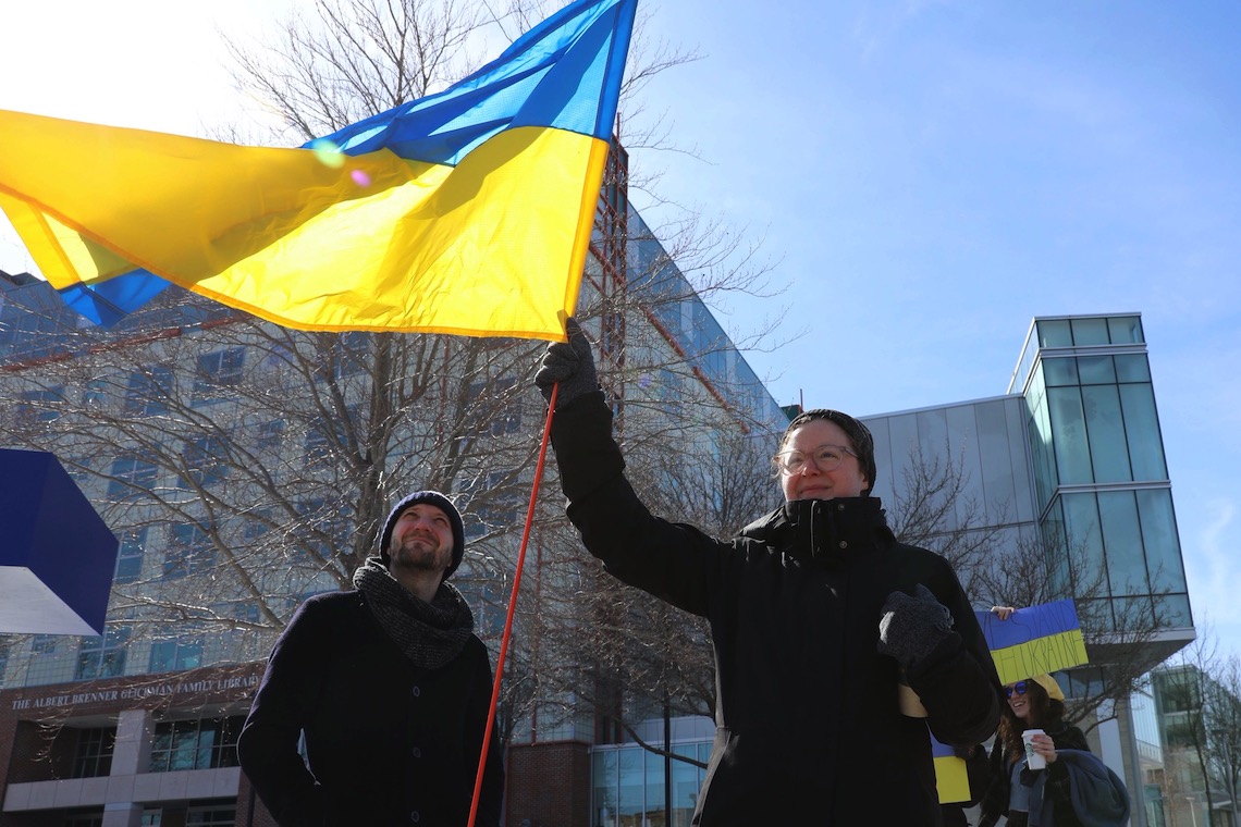 Demonstrators wave a Ukrainian flag to show support for that country in its war with Russia.