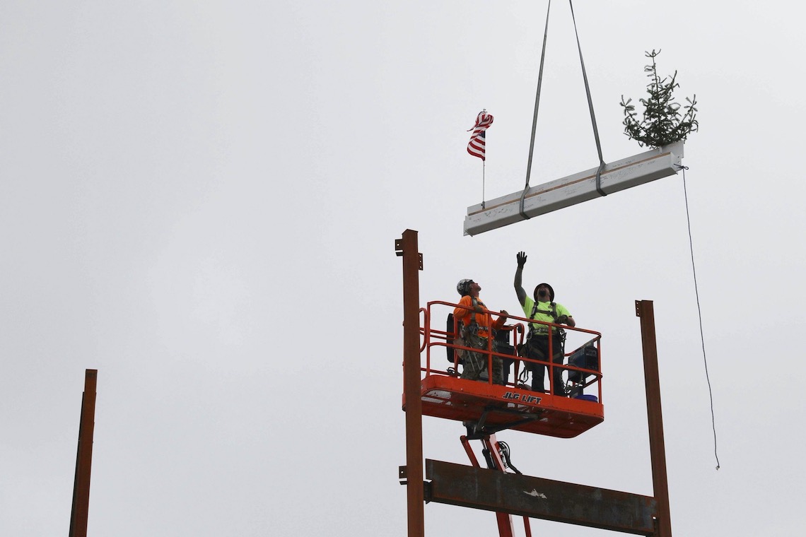 A ceremonial beam is fitted into place at the top of the future Portland Commons residence hall.