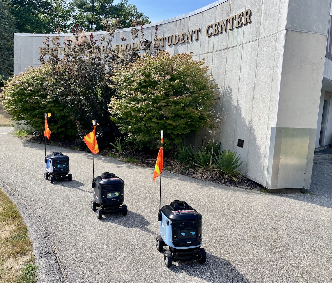 Kiwibots assemble in formation at Brooks Student Center before dispersing to deliver food across the Gorham campus.