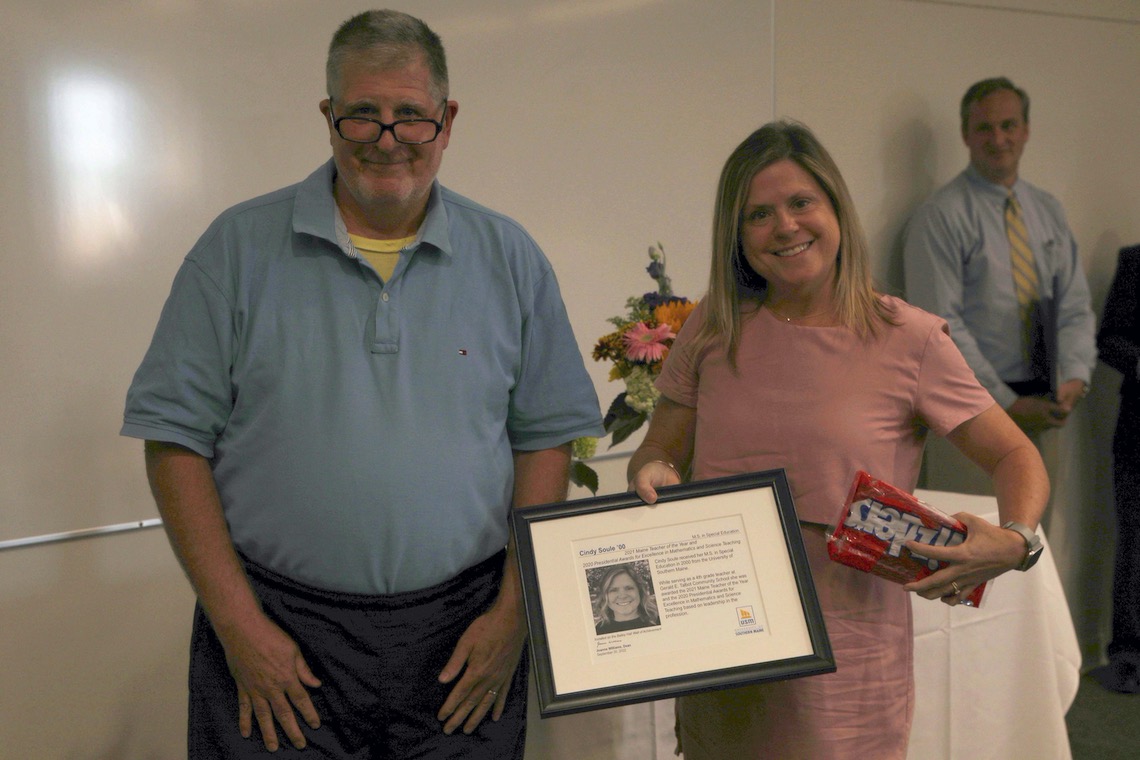 Dr. Walter Kimball presents Cindy Soule with a bonus award of Twizzlers at the School of Education and Human Development's recognition ceremony.