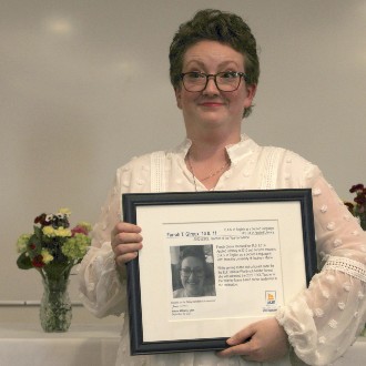 Farrah Giroux cradles her plaque after being inducted into the School of Education and Human Development's Wall of Achievement.