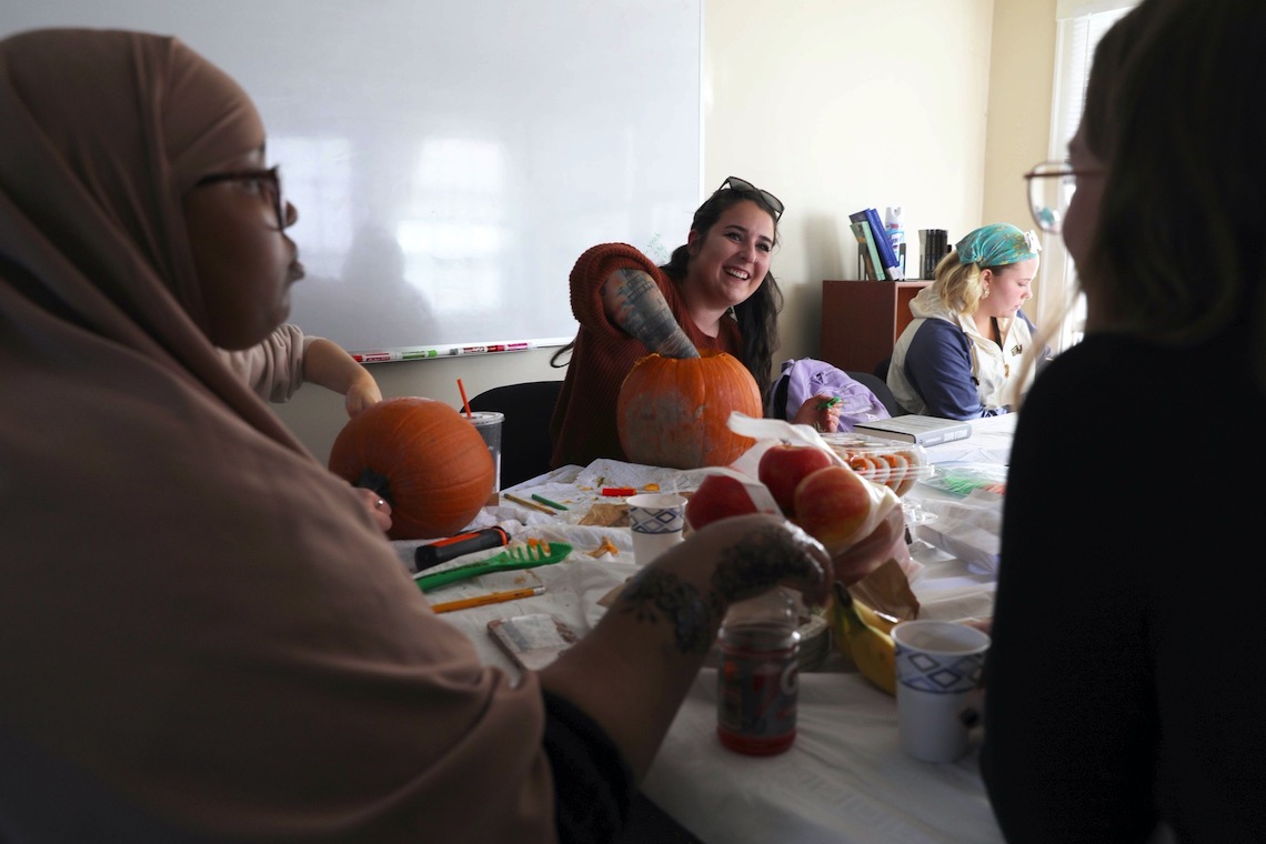 Before a pumpkin can be carved, it first needs to be relieved of its innards, as demonstrated by students at TRIO's jack-o-lantern workshop.