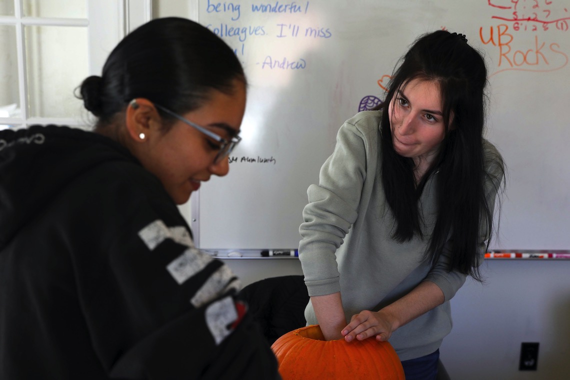 Sarah Beaulieu grits her teeth as she hollows out a pumpkin at TRIO's jack-o-lantern carving workshop.