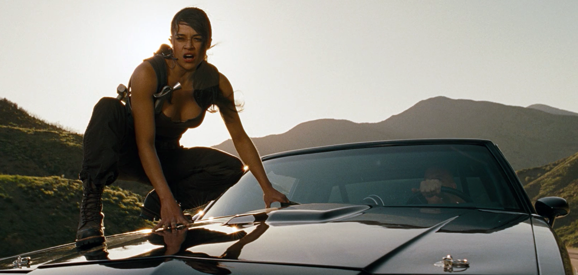 Fast and Furious Still image of woman balancing on hood of car