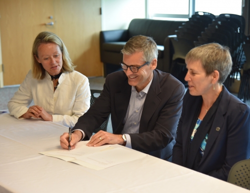 USM President Glenn Cummings signs agreement with Sigrid Ag and Aase Tveito of the University of Tromsø.