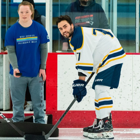 Tanner McClure gets and assist from his Best Buddy Charlie during the ceremonial puck drop to begin the game against Bowdoin on Jan. 1, 2023.