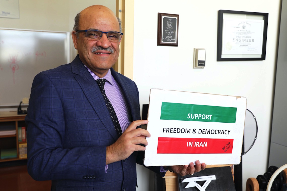 Dr. Mehrdaad Ghorashi displays a sign in support of democratic reforms in Iran.