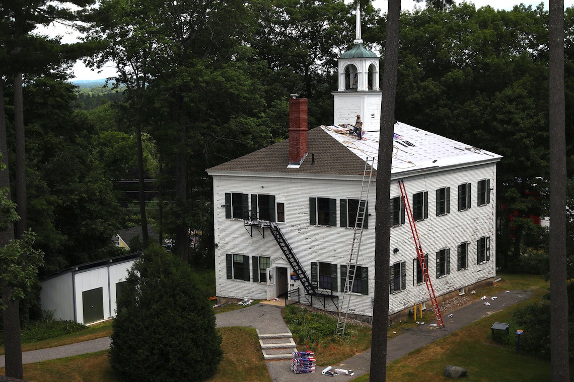 Roofers take a break after laying new shingles on the back section of the Academy Building.