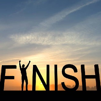 The word "FINISH" spelled out with a sunset background. A person is standing with their arms raised where the "I" in "Finish" is