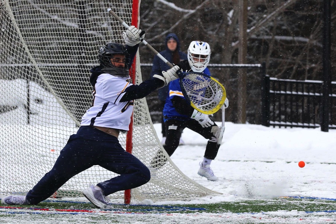 Addison Dietz swats away a shot on goal by Maine Maritime Academy in a men's lacrosse game on February 26, 2023.