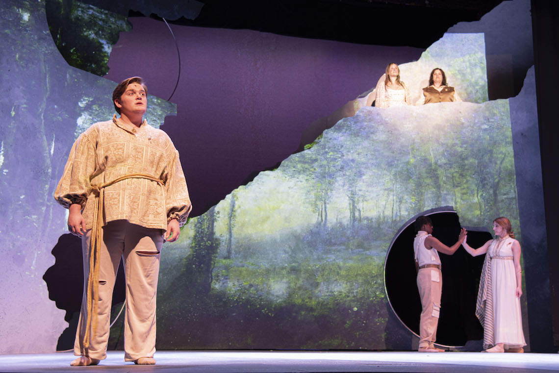 Orpheus (Oliver Scott) sings from the front of the stage as episodes in his life play out behind him in a scene from "Eurydice Rising."