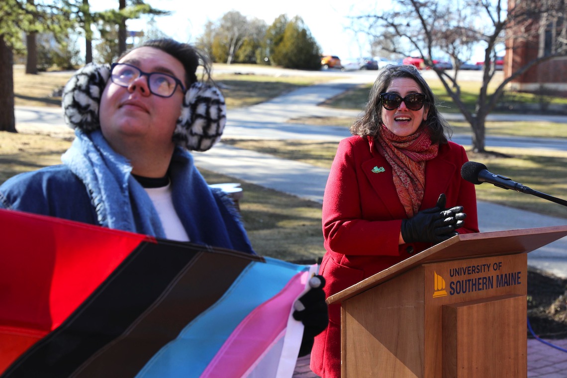 Assistant Vice President of Student Affairs Sarah Holmes watches as Bryan Spaulding helps raise the Intersex-Inclusive Progress Pride Flag.