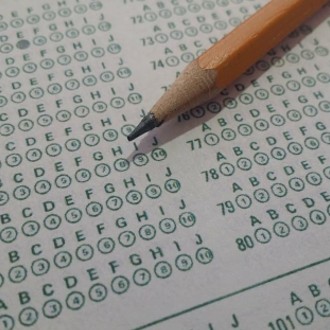 Close up image of a scantron bubble sheet with the tip of a pencil on top