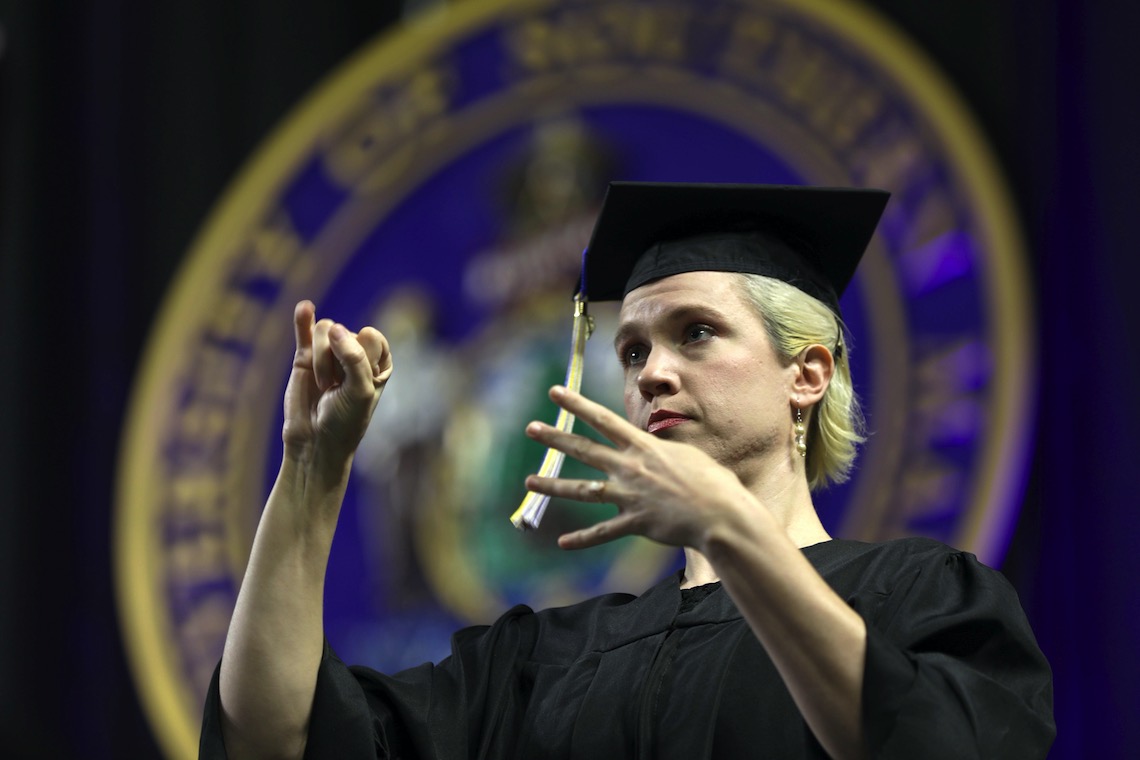 A graduate serves on the team of ASL interpreters who provide translation at the 2023 Commencement.