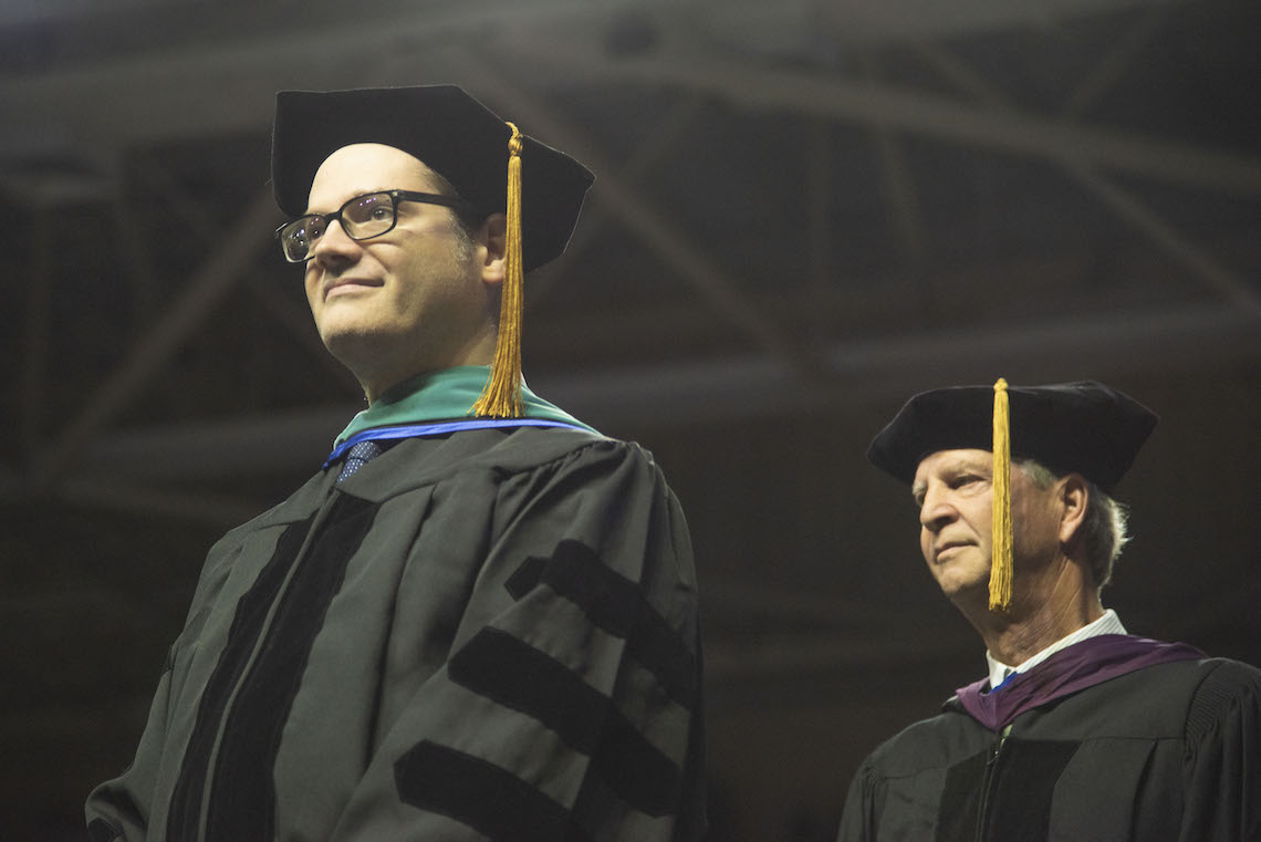 Dr. Jeff Beaudry smiles in acknowledgement of a newly hooded doctoral graduate at the 2023 Commencement.