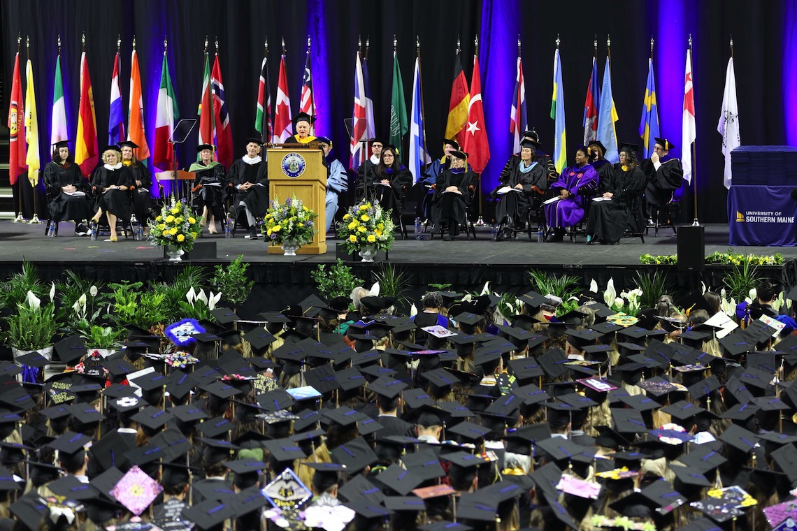 New York Times writer Neil Genzlinger looks over a sea of graduation caps as he delivers the keynote speech of the 2023 Commencement.