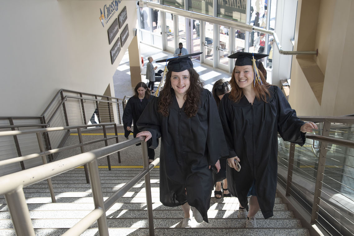 Graduates march up the stairs at the Cross Insurance Arena in Portland on their way to the 2023 Commencement.