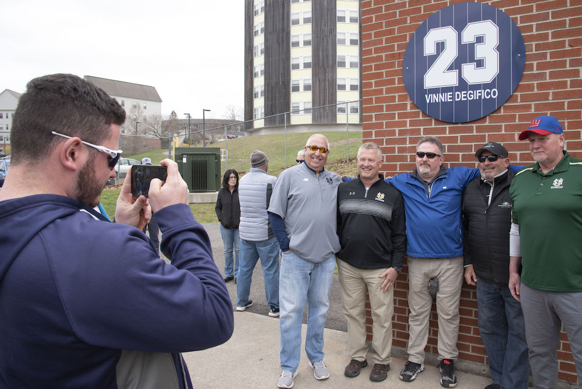Family, friends, and former teammates took turns snapping photos of the sign with Vinnie Degifico's newly retired number.