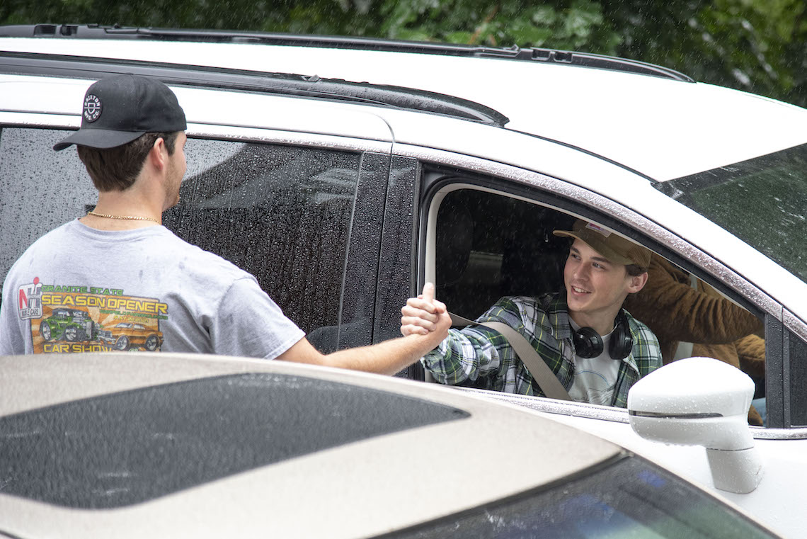 Two friends reunite with a handshake as they move into their dorms at Robie-Andrews Hall.