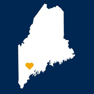Outline of the state of Maine with a gold heart over Lewiston