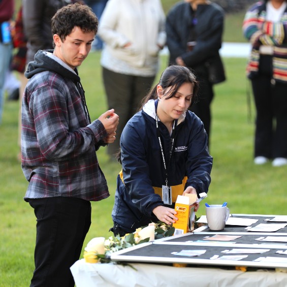During a vigil on the Bean Green, Student Body President Riley Worth gazes on the photos of the people who were killed in a mass shooting in Lewiston.